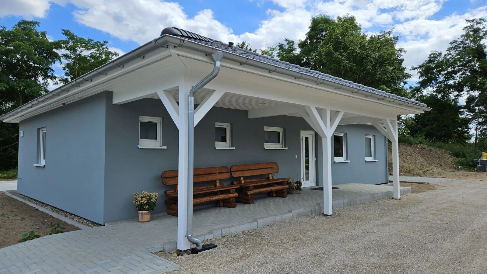 Eingangsbereich der Zweigpraxis Liepe mit überdachter Sitzbank